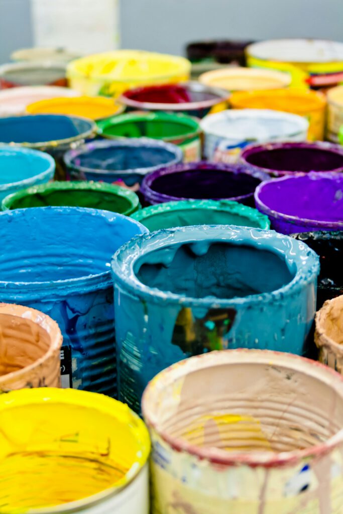 pexels-photo-1887946-1887946 A vivid assortment of open paint cans displaying a spectrum of colors, ideal for artistic and design projects.
